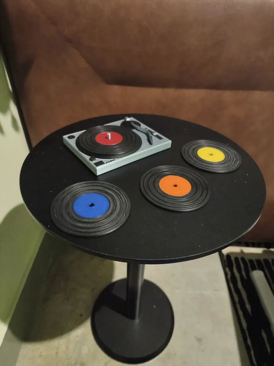 Porta-copos coloridos em formato de disco de vinil sobre a mesa